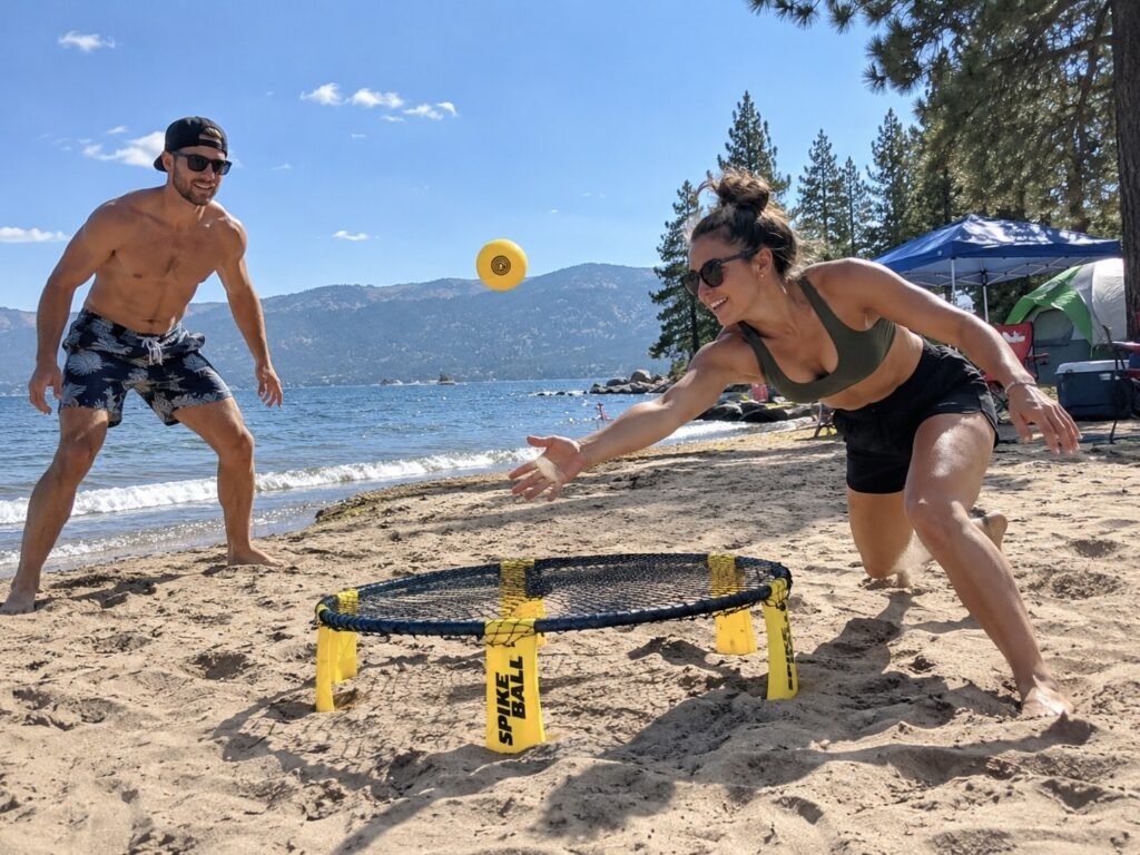 2 Adults playing Spikeball Roundnet Game on beach