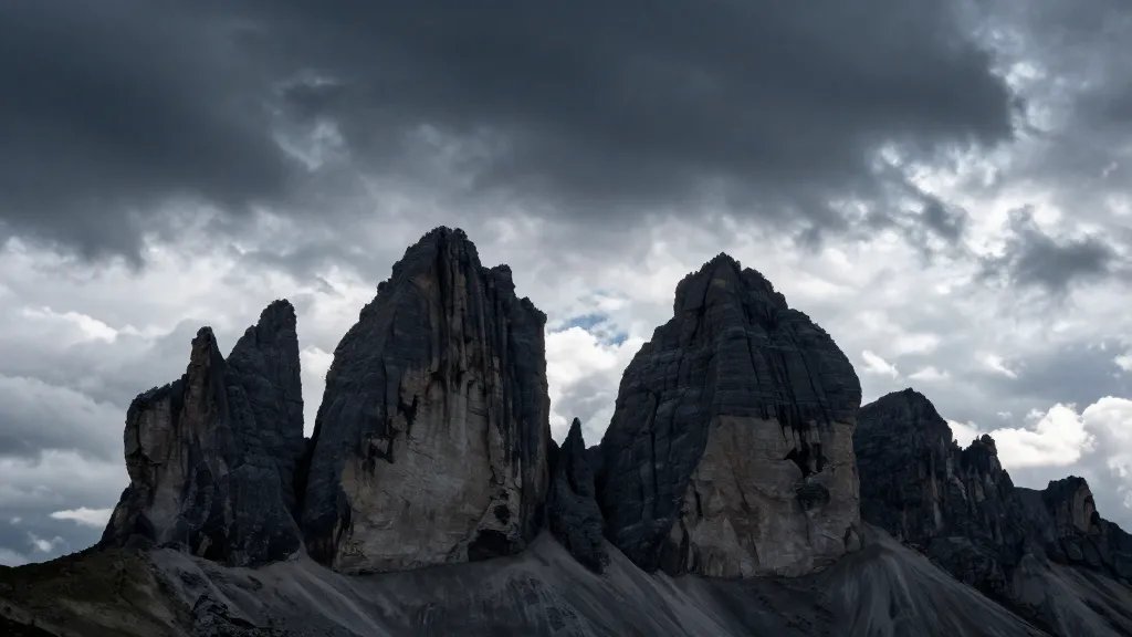 Far-off Tre Cime di Lavaredo silhouette under dramatic alpine sky