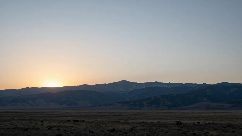 long-range sunrise over Sangre de Cristo Grand Vista, pale sun rising behind peaks