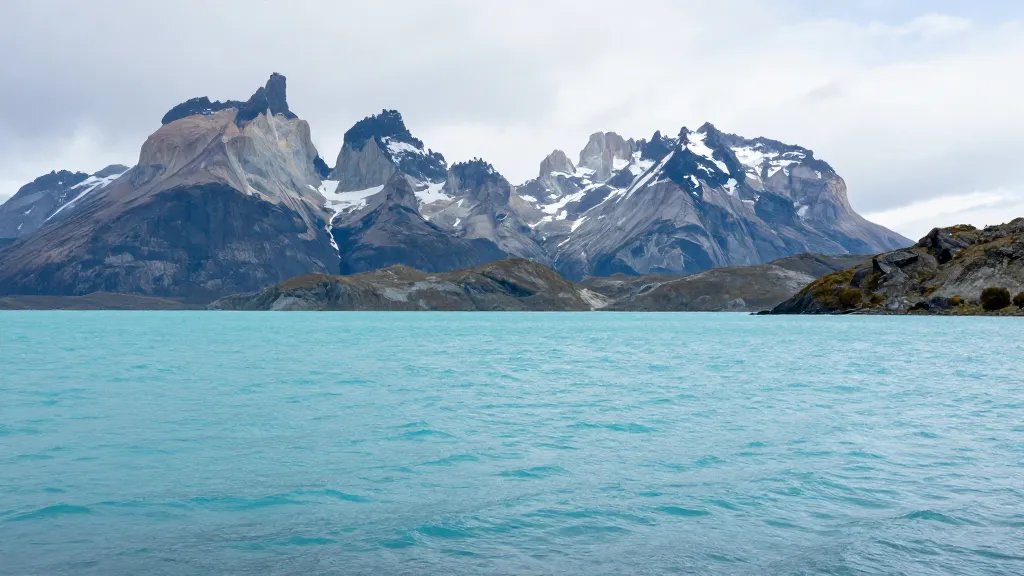 Silent turquoise Patagonian lagoon with jagged peaks in distance