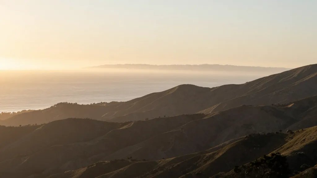 Distant panorama of Mount Tamalpais eastern face at sunrise, pale ocean glow