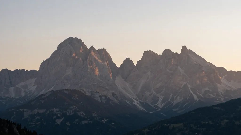 Distant sunrise over Dolomites jagged peaks in soft light