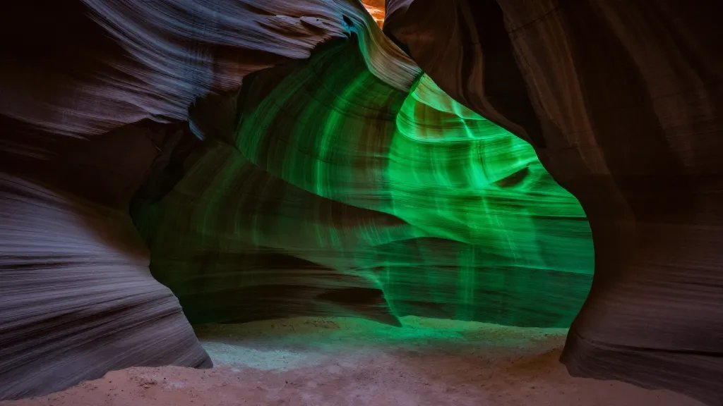 Wide, distant view of Zion’s Emerald Slot mouth lit by green glow