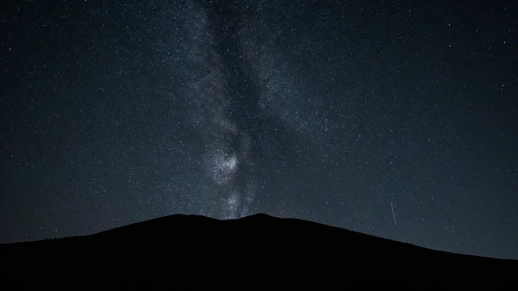 Far-off star-filled sky above alpine rim silhouette