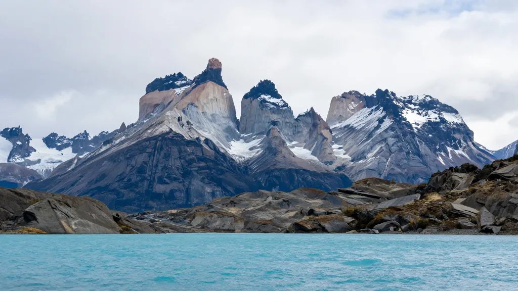 Distant view of Torres del Paine granite towers in Patagonian turquoise lake