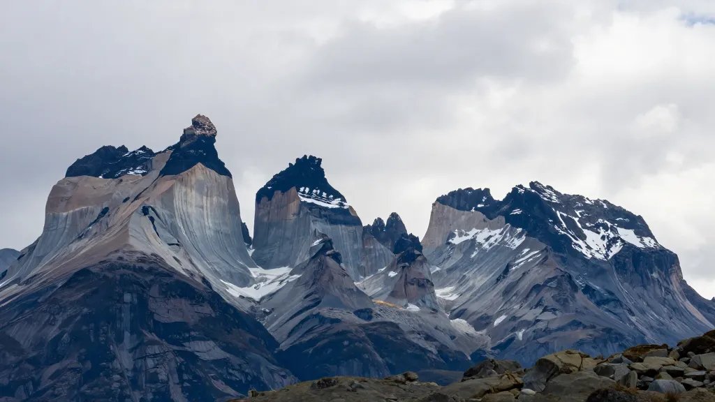 Distant shot of Torres del Paine jagged peaks against wind-swept sky