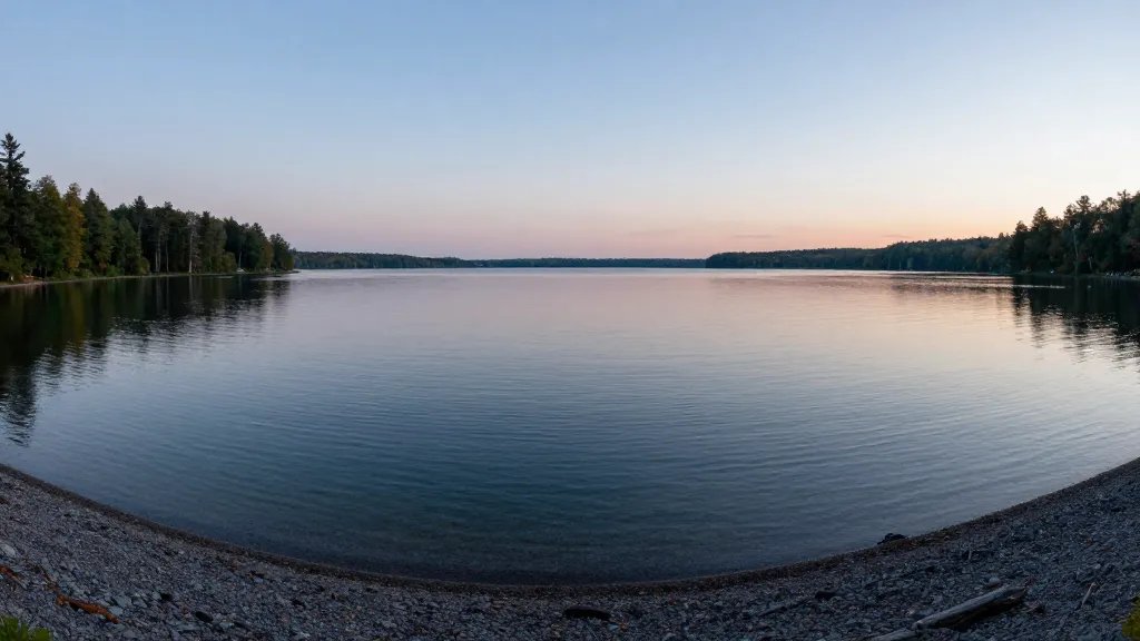 Panoramic overlook of crystal Lake McKay and calm shoreline at dusk