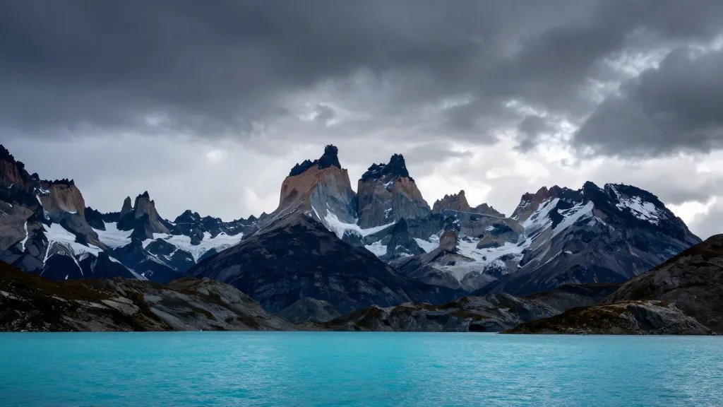 Far panorama of Patagonian turquoise lake with jagged towers silhouettes