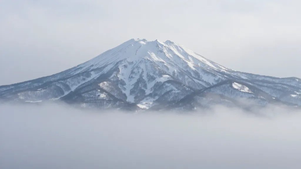Distant view of Niseko mountains shrouded in powder mist