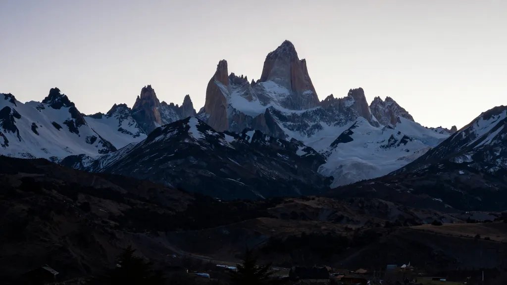 Panoramic distant view of Cerro Torre silhouettes against wind-swept Patagonian valleys