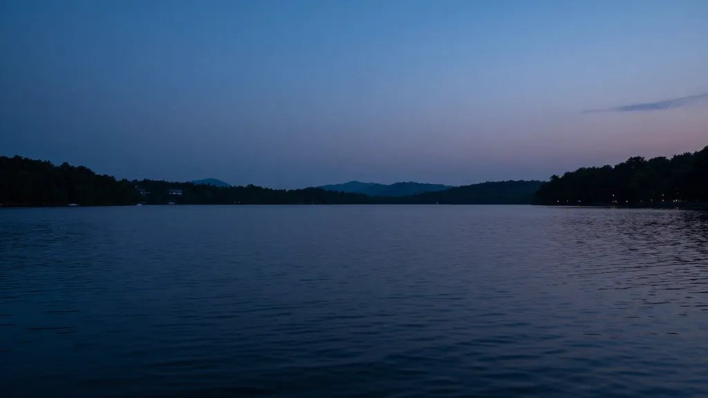 Remote lake show at blue hour, dark water reflecting subtle sky hues