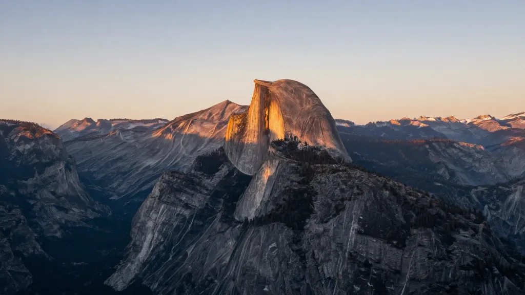Distant dawn view of Half Dome rising over Yosemite Valley at sunrise