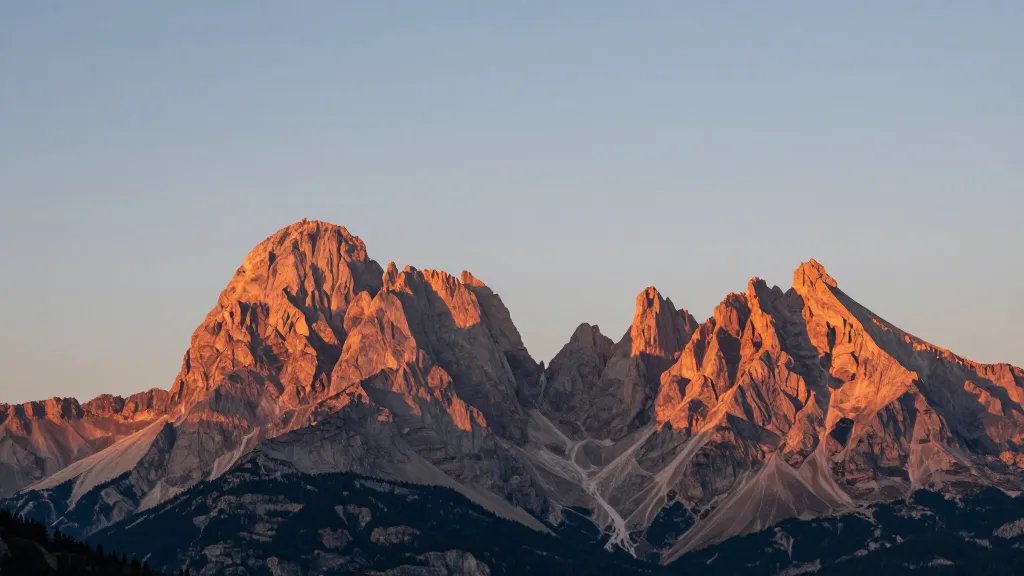 Distant panorama of rose-gold Dolomites peak silhouette at late afternoon