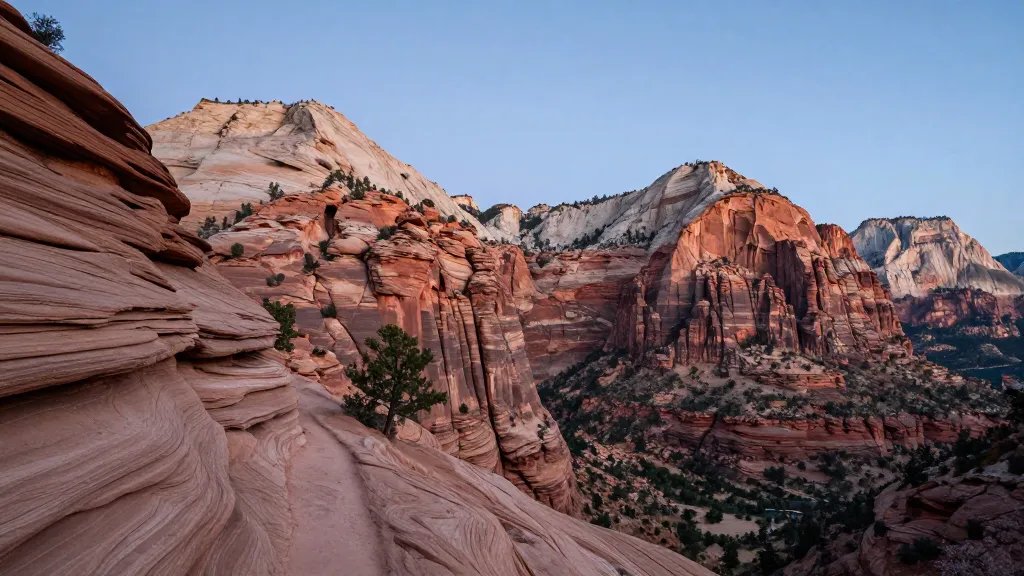 Expansive Zion Watchman Trail overlook with dramatic sandstone cliffs at dusk