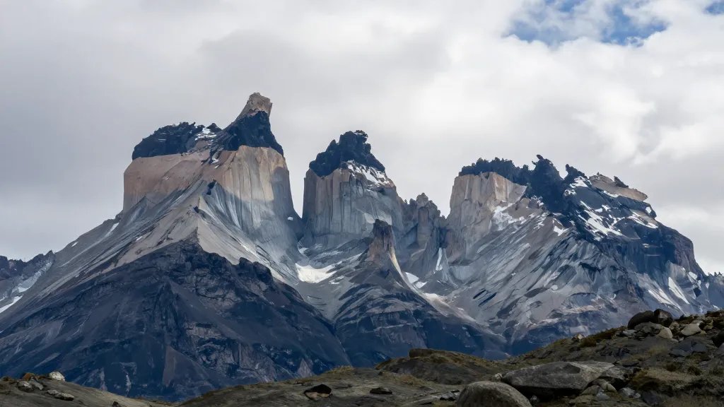Distant shot of Torres del Paine granite towers under wind-swept skies